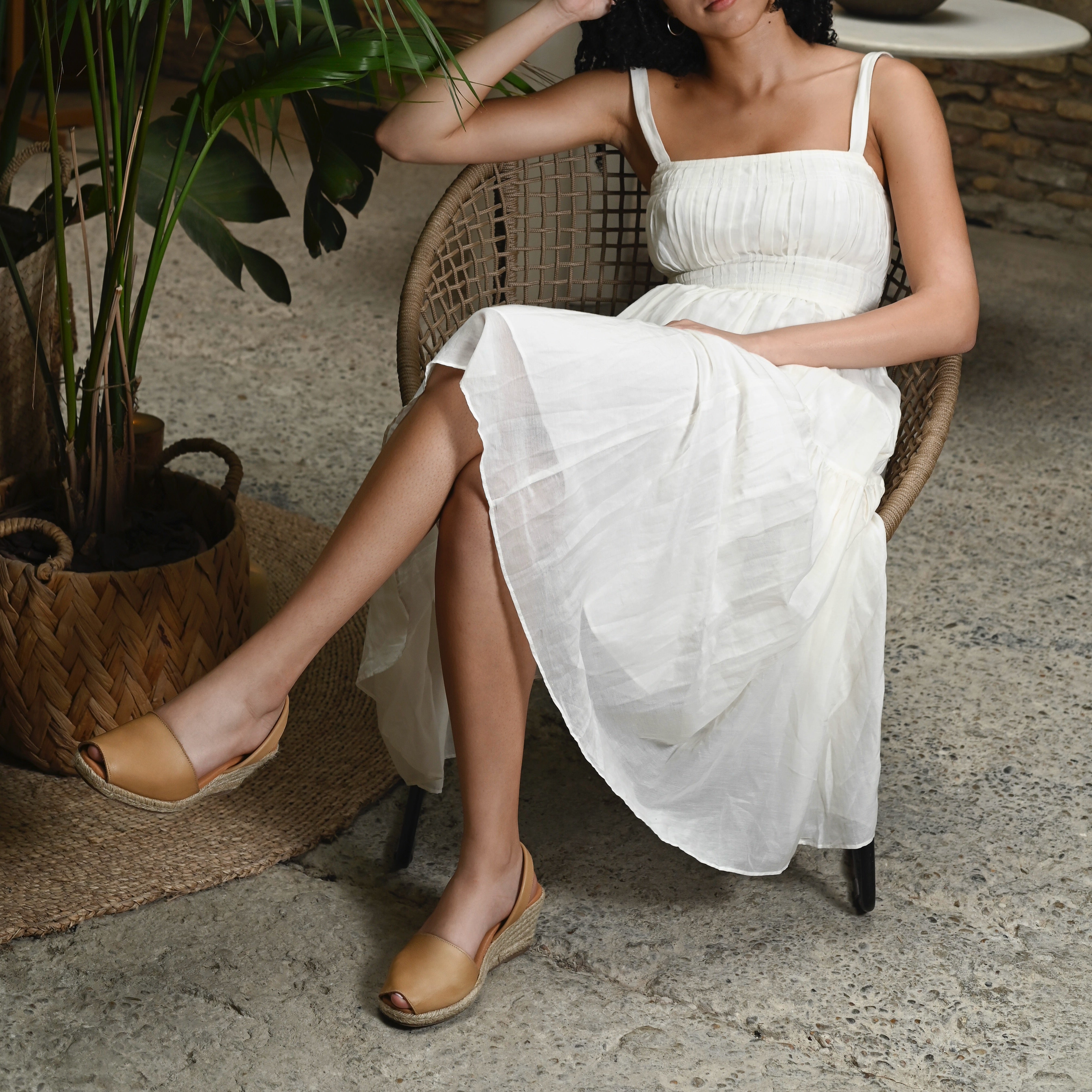 woman sitting in a chair wearing a white dress and almond espadrille wedges