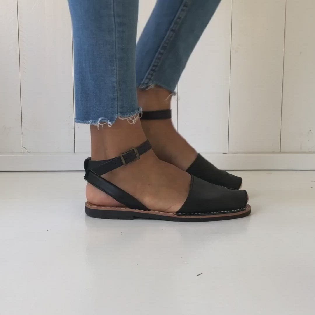 woman walking slowly with black sandals with straps