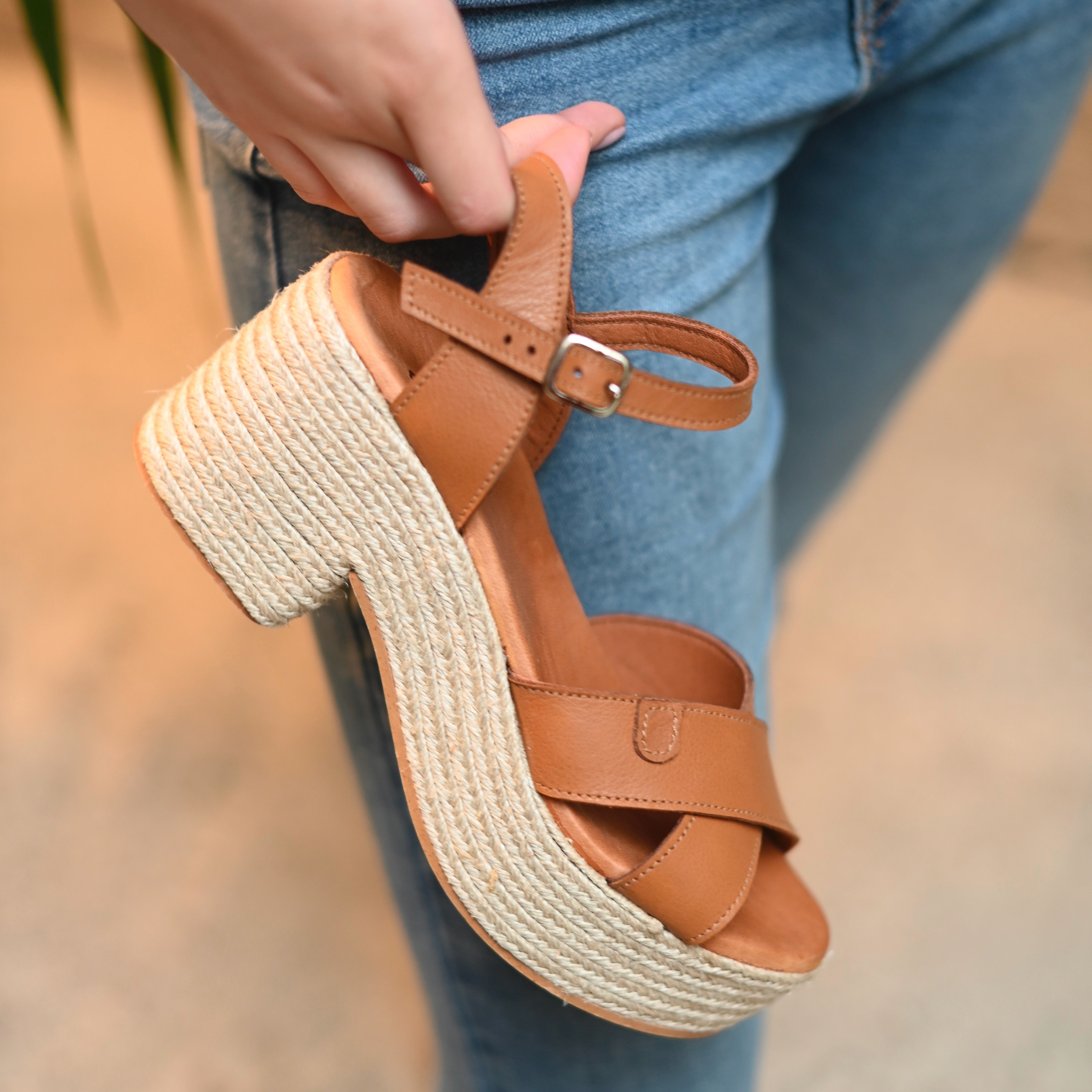 zoom in on a wedge sandals in a saddle color with a block heel