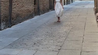 woman walking in the streets in Spain with a white dress and spanish sandals in tan nubuck